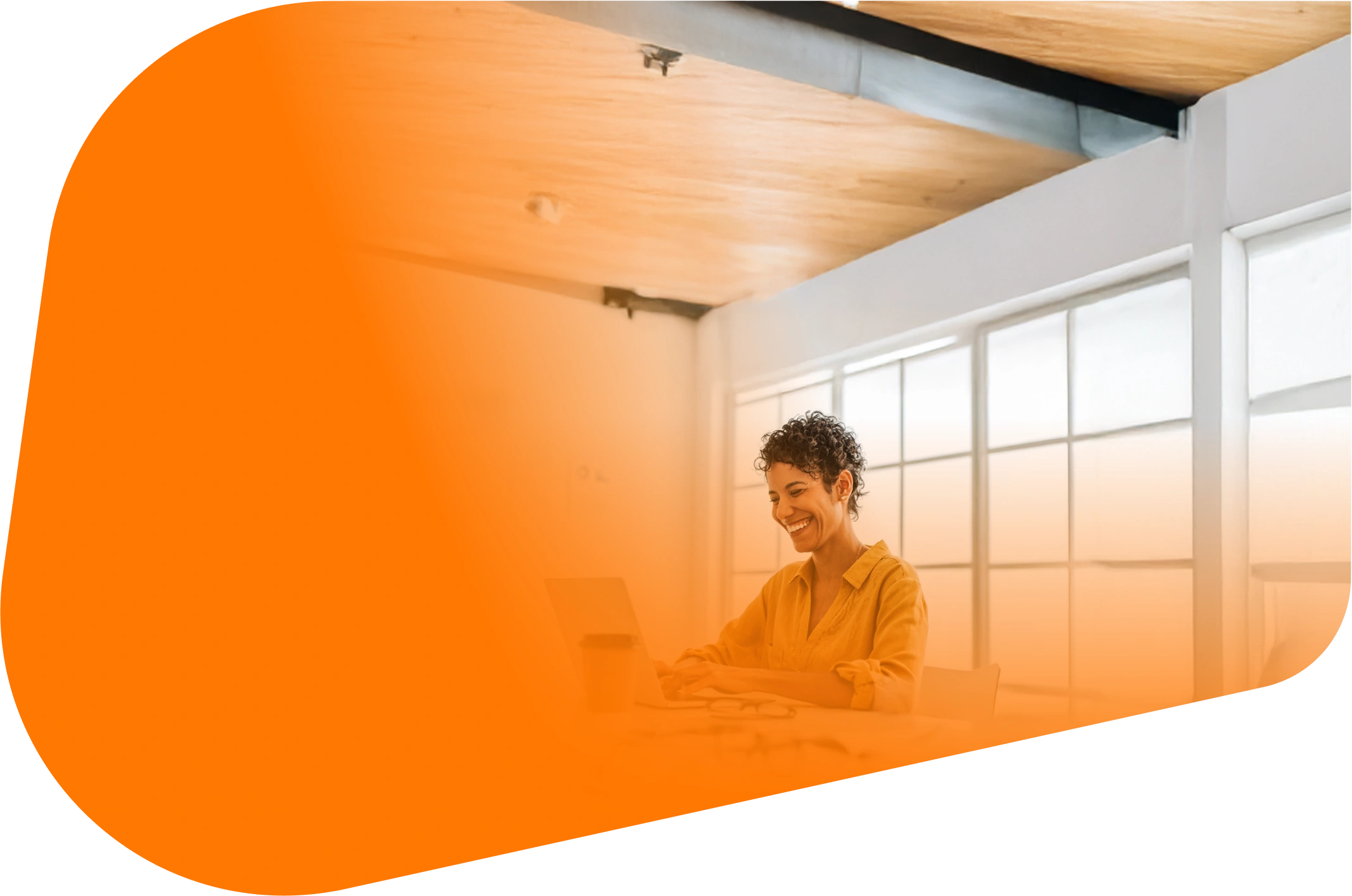 A person works on a laptop in a bright room. A large orange shape overlays the left side and softens the background