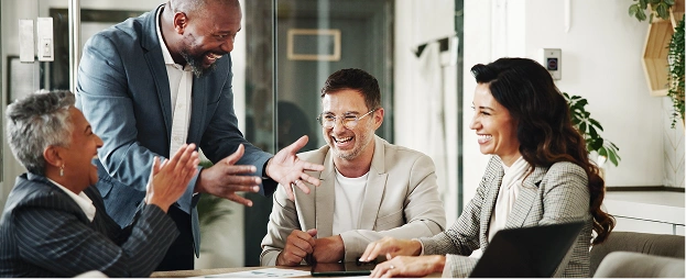 A small team sits around a table, talking and laughing