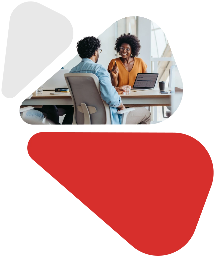 iamge to two people talking at the desk with laptop