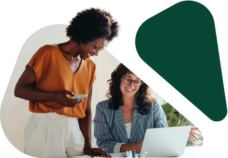 Two women collaborating at laptop in office