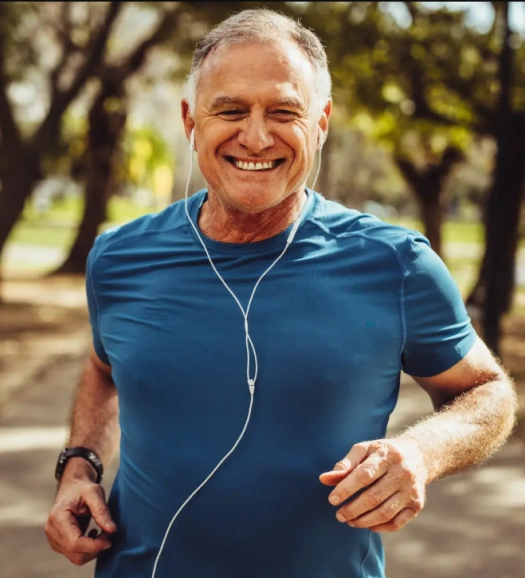 Smiling man jogging outdoors with earphones