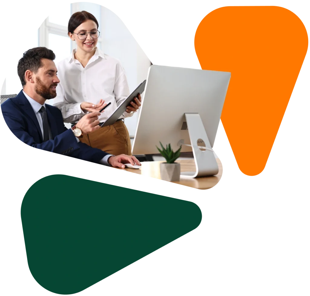 Two professionals collaborating at a desktop computer with abstract geometric shapes