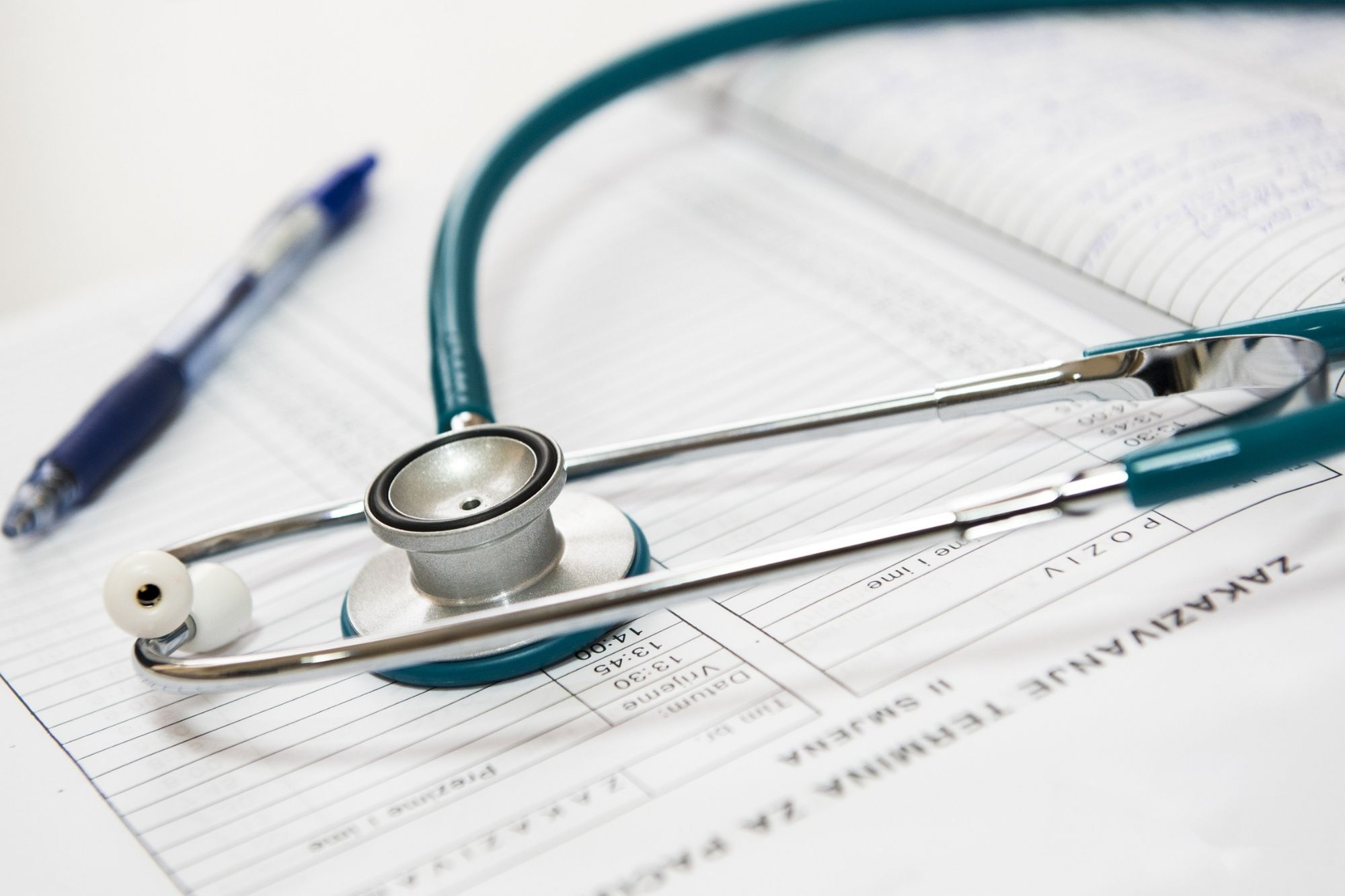 ballpen and stethoscope on top of documents