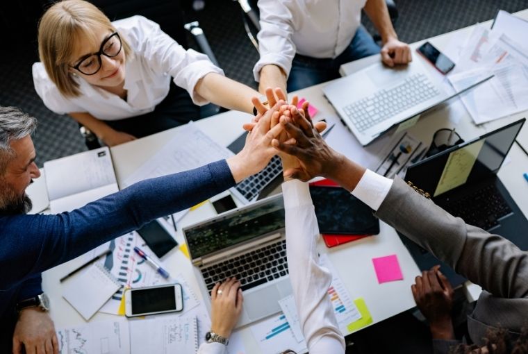 team of it personnel doing high five