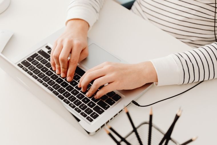 woman typing in her laptop