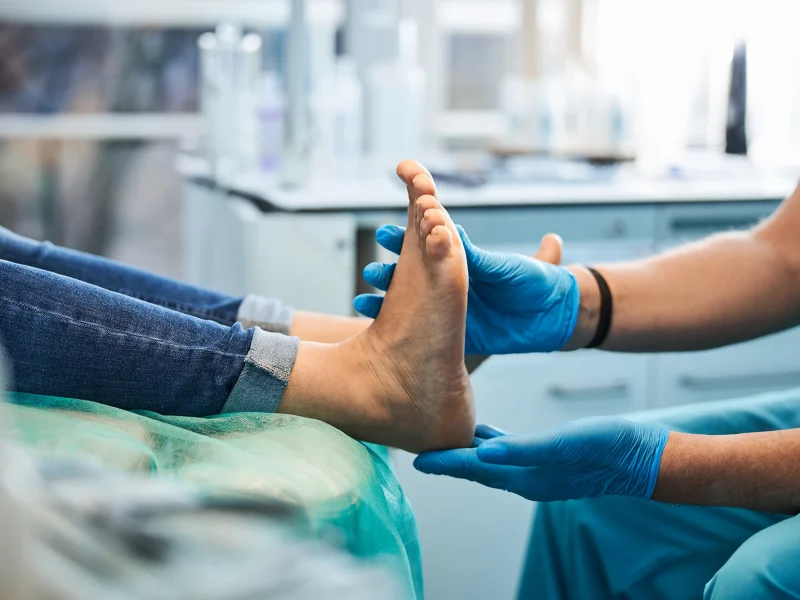Podiatrist examining patient foot during medical consultation in clinic setting